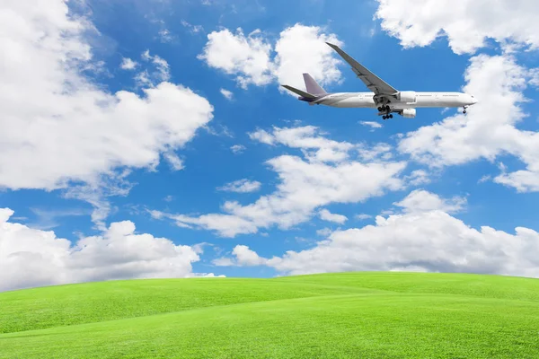 Grüne Wiese mit Flugzeug, blauem Himmel und Wolkenhintergrund. — Stockfoto