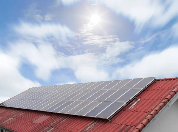 Güneş paneli ve kırmızı çatı mavi gökyüzü ve güneş güneş enerjisi paneli 