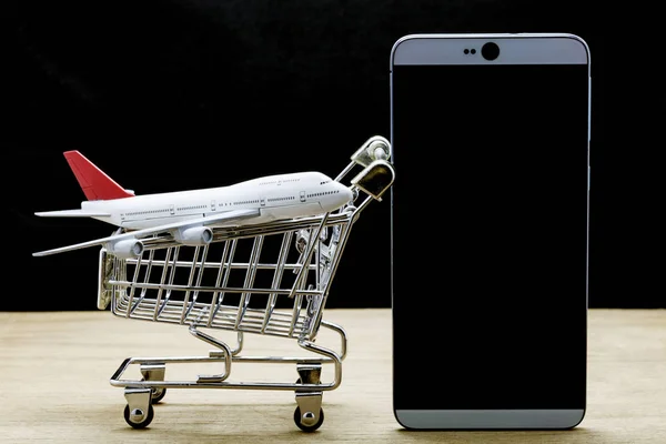 Teléfono móvil con modelo de avión y carrito de compras en madera, Onli — Foto de Stock