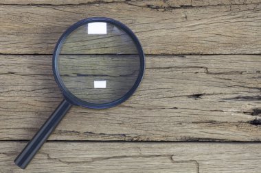 eski ahşap masa arka plan üzerinde büyüteç.