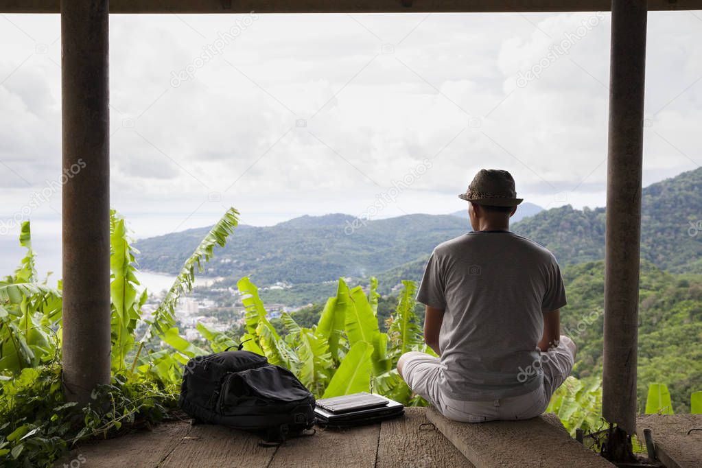 Man traveler sitting relax against beautiful scenery with backpa