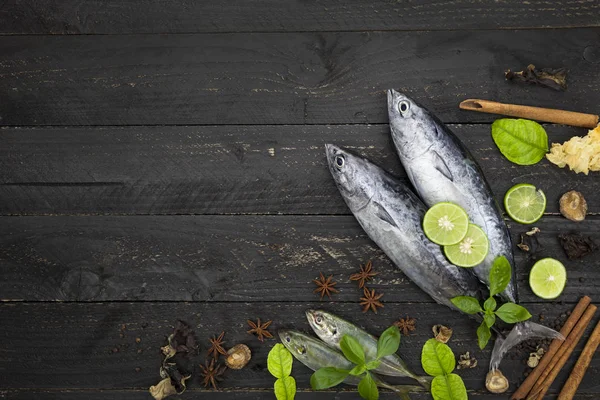 Koyu siyah arka plan, baharatlar ile balık üzerinde taze balık 