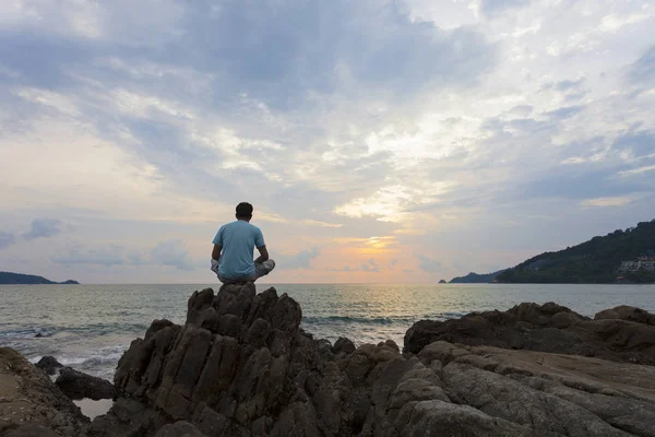 Alone man sitting on the stone in the evening. — Stock Photo, Image