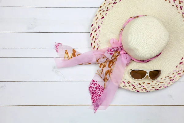Top view of beach hat ,sunglasses on white wooden background.