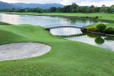 Golf sahası yeşil çimen alanı ve göl.