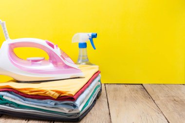 renkli kıyafetler sarı arka plan yığını üzerinde demir.