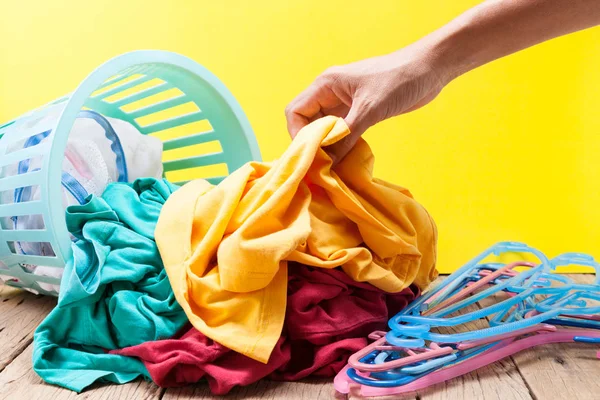 Kirli sepeti ahşap, sarı backgro üzerinde yıkama içinde çamaşır yığını