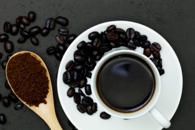 fincan kahve ve siyah ahşap tahta kaşıkla kahve çekirdekleri 