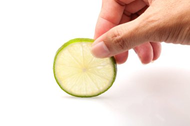 Beyaz arka plan üzerinde izole limon dilimi el tutar.