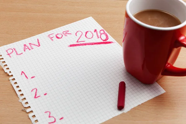 Plan for 2018 text on paper note with coffee cup