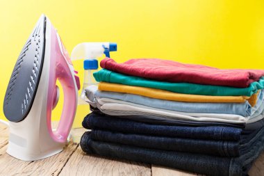 demir ve renkli elbise yığını arka plan sarı.