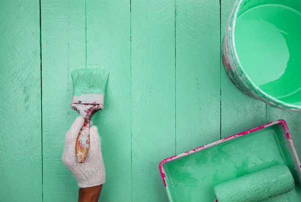 Hand groene kleur op houten tafel schilderen. — Stockfoto