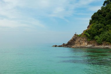Yalnız adam taş tropikal deniz başparmak yukarıya ayakta tutan
