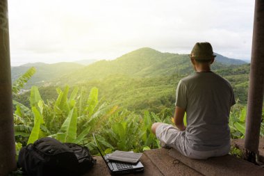 Manzara manzara rainforest karşı oturan seyahat adam 