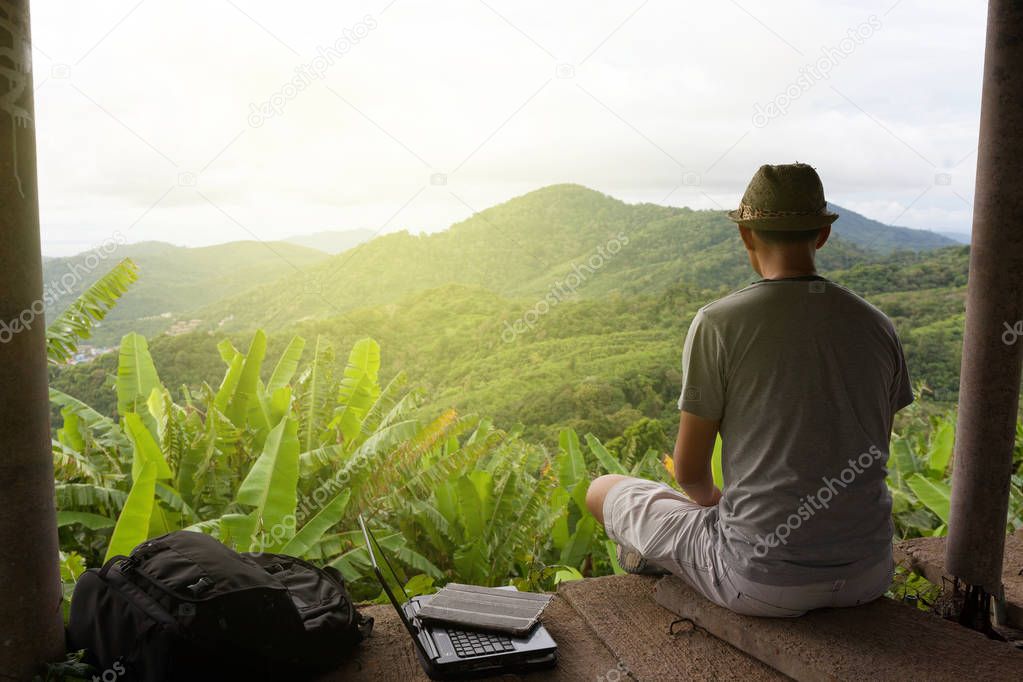 Traveler man sitting against scenery landscape rainforest 