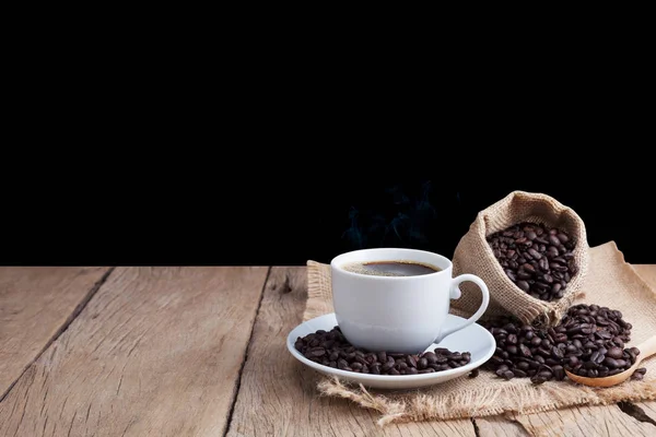 Φλιτζάνι καφέ και κόκκους καφέ σε παλιά ξύλινη σανίδα φόντο. — Φωτογραφία Αρχείου