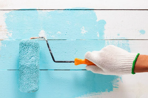 Hand blauwe kleur op witte houten tafel schilderen. — Stockfoto