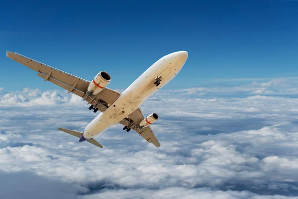 Handlowych samolot leci ponad chmury i błękitne niebo — Zdjęcie stockowe