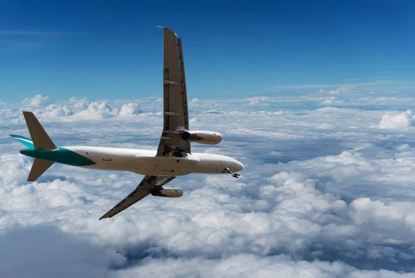 Avion commercial volant au-dessus des nuages et ciel bleu clair — Photo