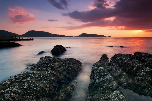 Lange blootstelling beeld van dramatische hemel zeegezicht met rock in de zonsondergang — Stockfoto