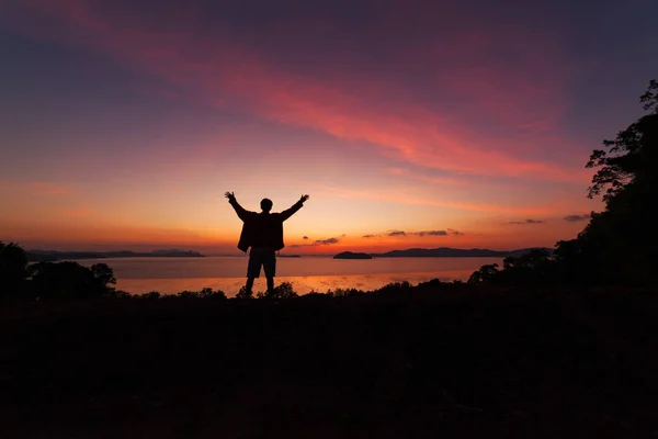 Beautiful dramatic sunrise with man standing raised-up arms — Stock Photo, Image
