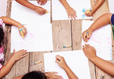 Çocuk el ile renkli kalemler tahta masada çizim