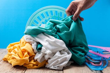 Kirli çamaşır yıkama sepeti ahşap tahta üzerinde içinde tutan el