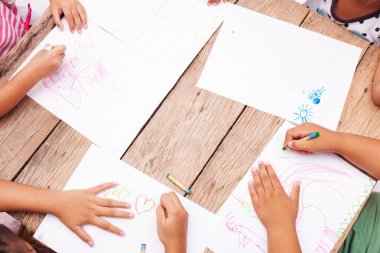 Çocuk el ile renkli kalemler ahşap masa üzerinde çizim co