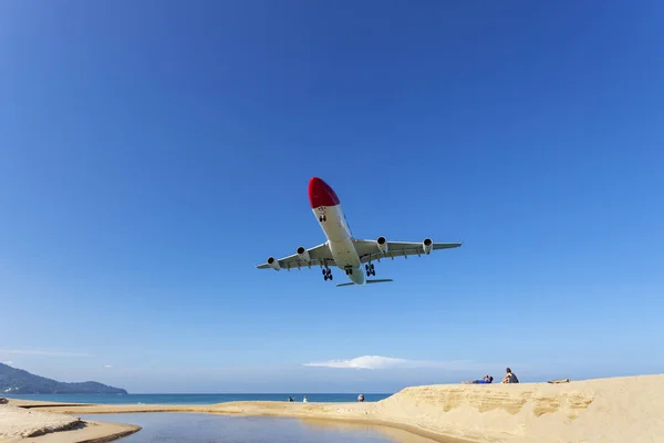 Commercial airplane landing above sea and clear blue sky — Stock Photo, Image