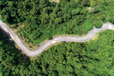 Asfalt yol eğrisinin üst görüntüsünü gösteren hava aracı görüntüsü
