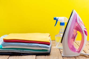 demir ve renkli elbise yığını arka plan sarı.