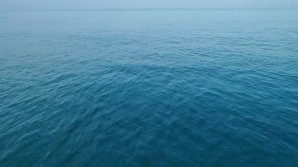 Yaz mevsiminde okyanus üzerinde uçan insansız hava aracı, bulutlar ve mavi gökyüzü görüntüleriyle hava aracının hava görüntülerinden güzel deniz yüzeyi üstüne kameralar yukarı doğru eğiliyor.