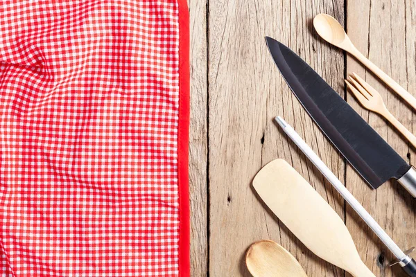 Konyhai eszközök, kés, fakanál a régi fa asztalon és piros — Stock Fotó