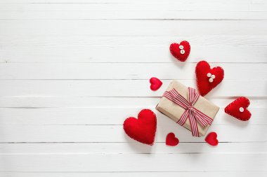 Hediye kutusu ve kalpleri beyaz boyalı ahşap planı üzerinde arka plan
