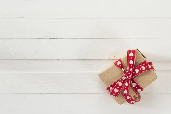 Confezione regalo con nastro rosso su tavolette di legno verniciato bianco e vuoto — Foto Stock