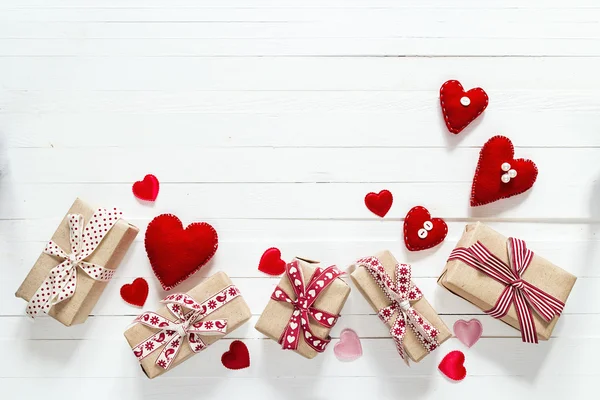 Background with gift boxes and hearts shapes on white painted wo — Stock Photo, Image