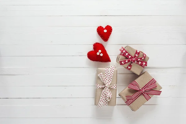 Background with gift boxes and hearts on white painted wooden pl — Stock Photo, Image