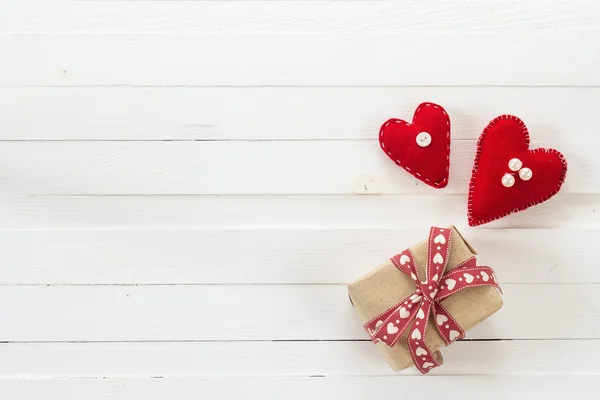 Sfondo con scatola regalo e cuori su disegno in legno verniciato bianco — Foto Stock