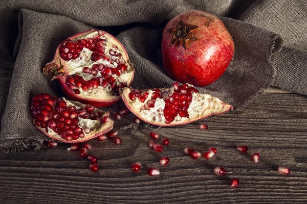 Still life with fresh juicy pomegranate on sackcloth on on rusti — Stock Photo, Image