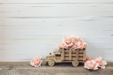 Ahşap oyuncak kamyon arka yüzünde bir beyaz pembe Gül çiçeklerle