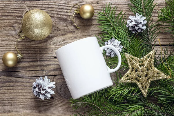 White coffee mug with gold Christmas decorations and fir branche