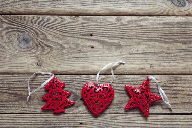 Arka plan eski ahşap kurullarında kırmızı Noel süslemeleri ile. 