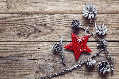 Arka plan kırmızı Noel yıldızı ve beyaz boyalı çam kozalakları ile 