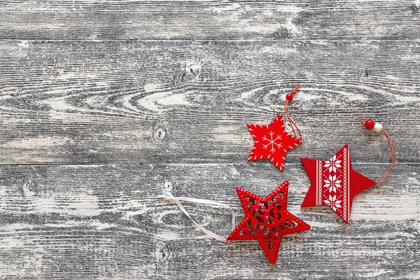 Hintergrund mit rotem Weihnachtsschmuck Sterne auf grauem Holz — Stockfoto