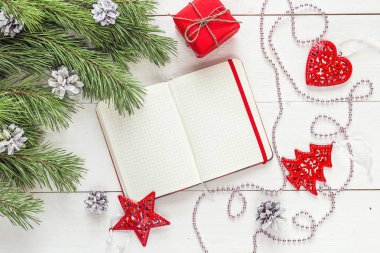 Boş açık not defteri, Çamın dalları ve Noel dekorasyonları üzerinde bir