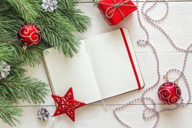 Boş açık not defteri, Çamın dalları ve Noel dekorasyonları üzerinde bir