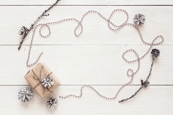 Fond d'hiver avec perles de Noël, boîte cadeau et cônes. Spac — Photo
