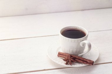 Tarçın ve anason Beyaz ahşap bir masa üzerinde beyaz kahve fincanı