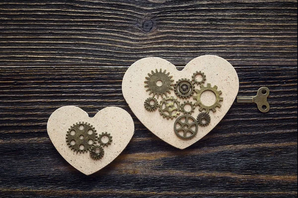 Background with shape of hearts, the gear mechanism and a key on