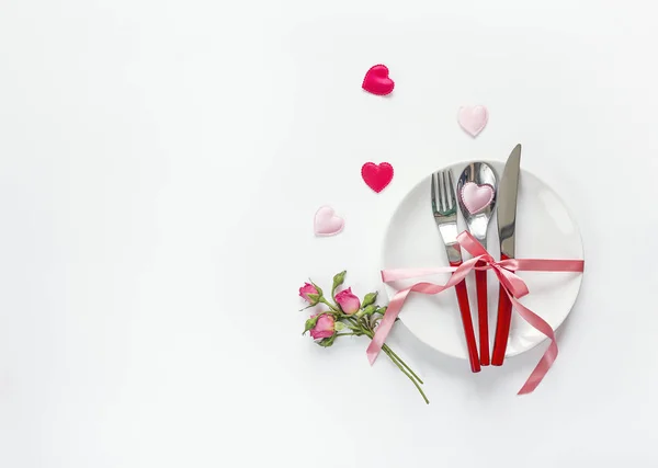 Romantic festive table setting with cutlery, roses and hearts on — Stock Photo, Image